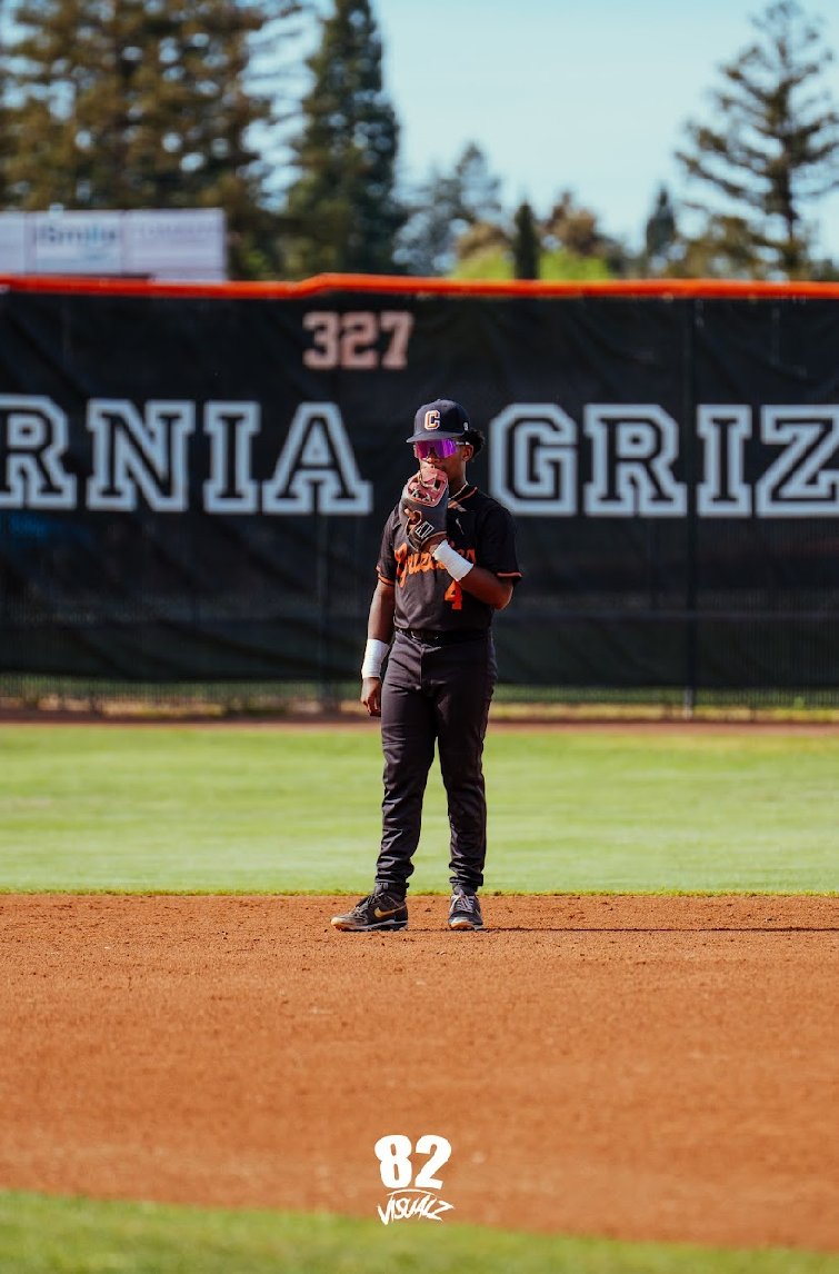Kai Watts in position at shortstop in front of the Grizzlies banner