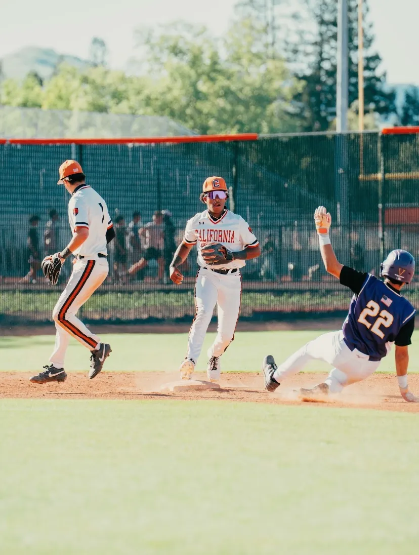 Kai Watts at second base with the ball in his glove as a runner slides in