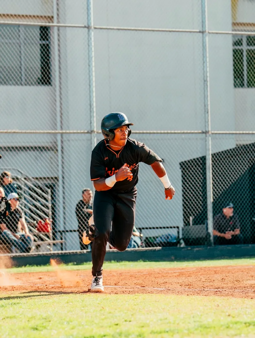 Kai Watts running out of the batter's box in the black Grizzlies uniform