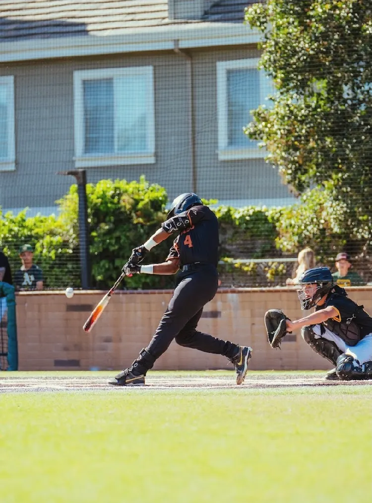 Kai Watts, #4, making contact on a swing in the black Grizzlies uniform